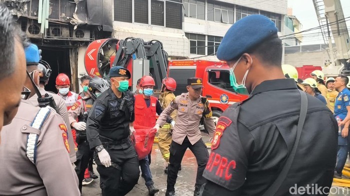 1765278364730-petugas-bolak-balik-membawa-kantong-jenazah-dari-dalam-gedung-kebakaran-di-jakpus-ke-ambulans-1765275592972_169